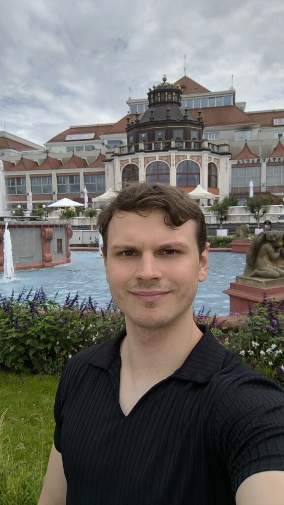 Daniel Terasa, Coach für Angst-, Panik- und Kontroll-/Zwangsreaktionen sowie Krankheits-/Gesundheitsangst, im Freien vor einem Kurhaus.